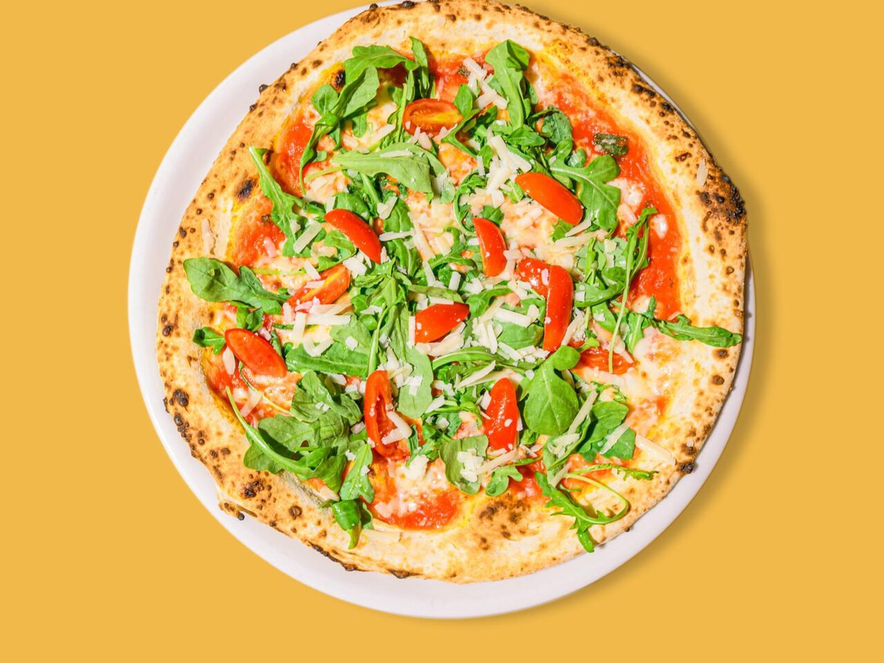 Pizza con rucola, pomodorini e grana